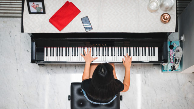 Woman playing piano, photo taken from overhead, photo credit @jon_chng